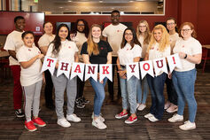 A group of Honors Program students holds a thank you banner.